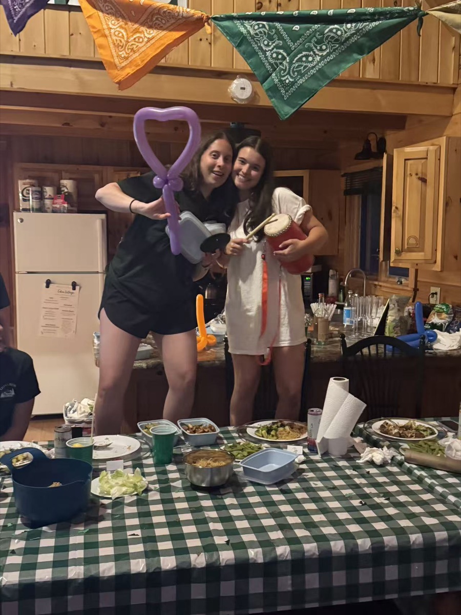 Friends posing with a balloon heart at a hibachi catering party in New England