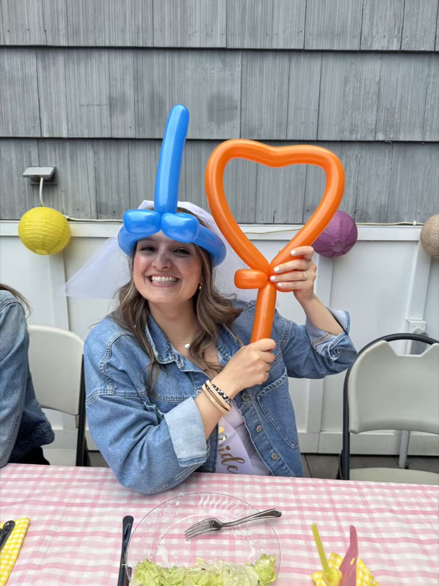 Happy guest holding a balloon heart at a hibachi catering party in New England