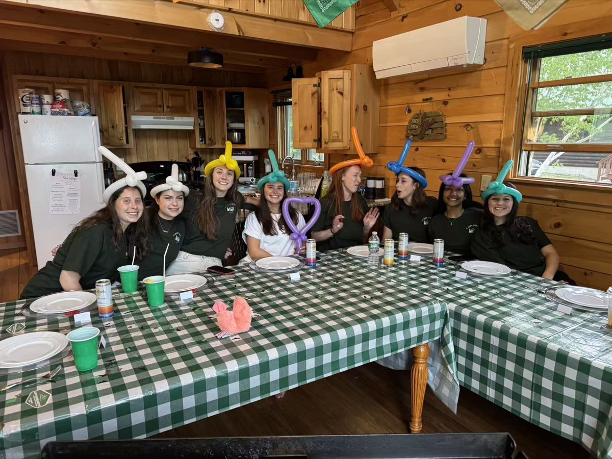 Group celebrating with balloon hats at an indoor hibachi party in New England