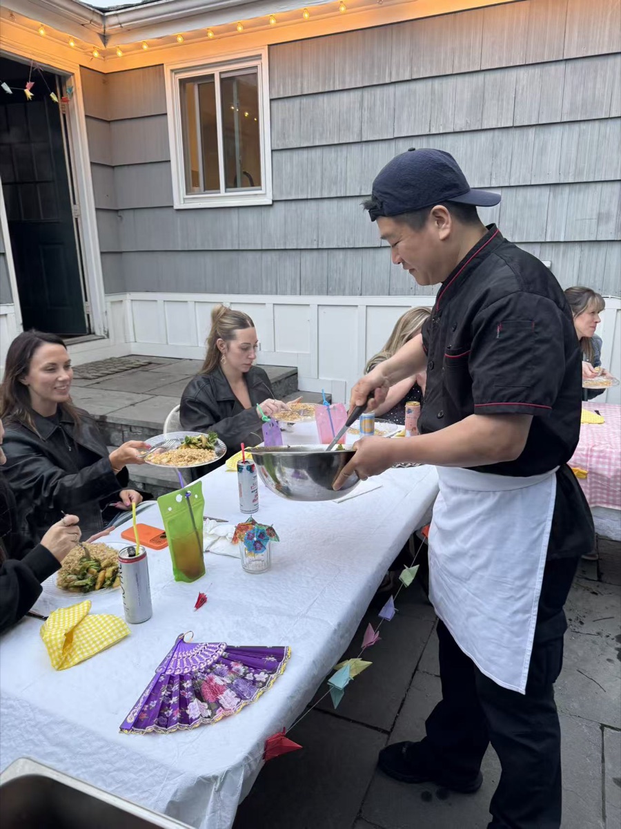 Hibachi chef serving freshly cooked food to guests at a New England event