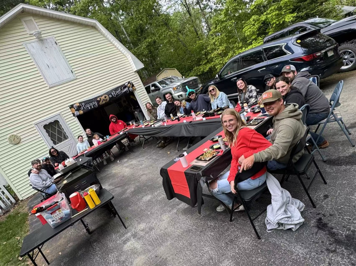 Outdoor hibachi catering party with guests dining at long tables in New England